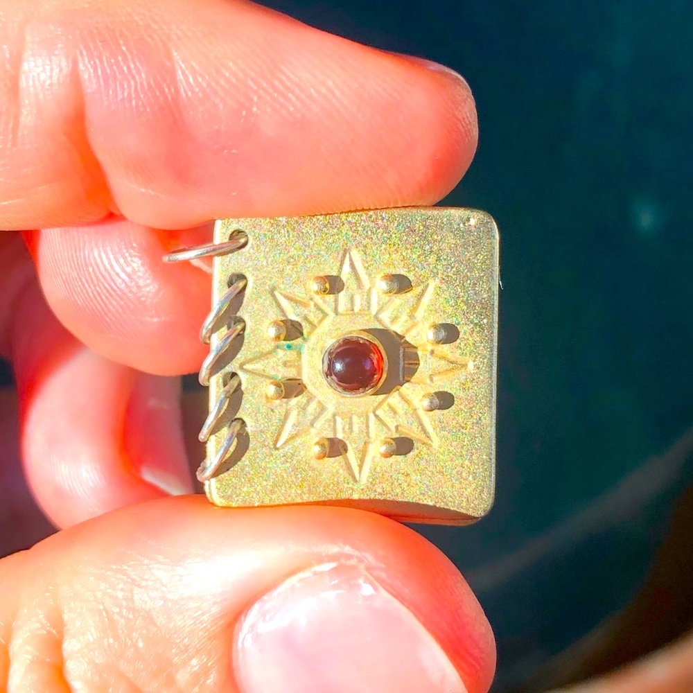 Beautiful book pendant with garnet stone.